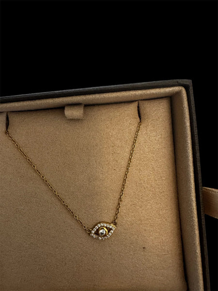 Close-up of gold evil eye pendant showing intricate design details