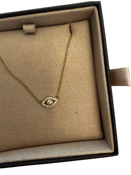 Woman wearing gold evil eye necklace, elegant jewelry styling