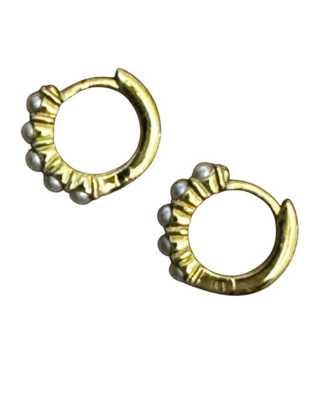 Close-up of synthetic pearl claw-set design in gold vermeil huggie earrings